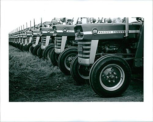 Гроздобер фотографија на нов бренд Меси Фаргус трактори паркирани на фарма.